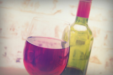 Bottle of red wine with glass ready to pour