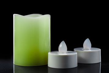 led candles on glossy surface on black background