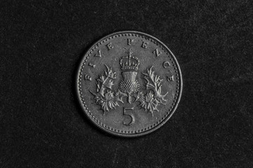 Close up of  five pence coin on black background - business concept