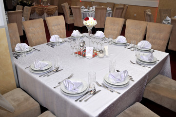 Cutlery with colorful flowers, jewelry and scented candles are placed at round tables for the guests traditional weddings, Novi Sad, Serbia