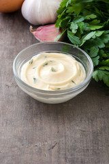 Aioli sauce and ingredients on wooden background
