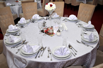 Cutlery with colorful flowers, jewelry and scented candles are placed at round tables for the guests traditional weddings, Novi Sad, Serbia