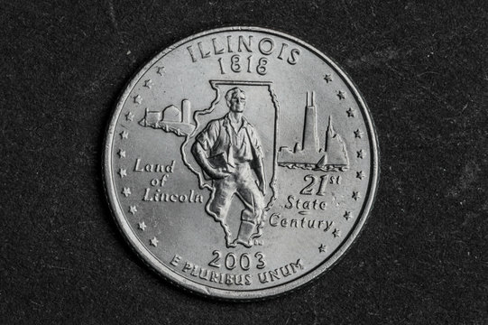 Close up of Illinois quarter dollar coin on black background - business concept