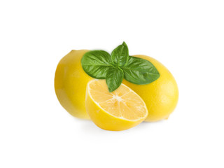 Two lemons and halves isolated on white background. Ripe lemons with basil close-up. Background citrus.