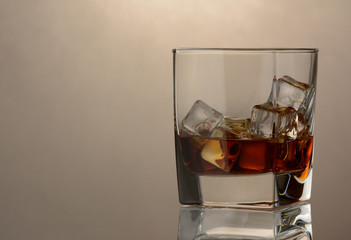 A glass of whiskey on grey background
