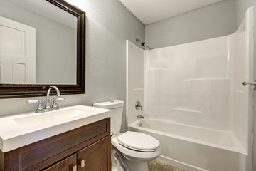 Fototapeta na wymiar Compact light bathroom with soft gray walls