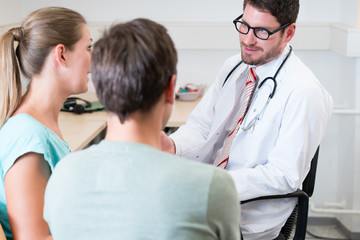 Fototapeta premium Pregnant woman and her partner seeing physician