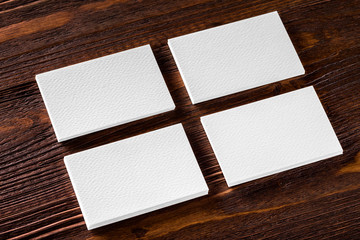 Closeup mockup of four blank vertical business cards at brown wo