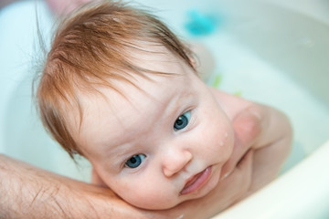 Bathing baby in a baby bath.