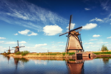 Naklejka premium Colorful spring day with traditional Dutch windmills canal in Ro
