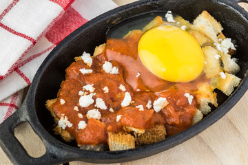 Unbaked eggs with marinara and feta.