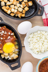 Unbaked eggs with marinara and feta.