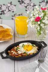 Breakfast with shirred eggs with marinara and feta.