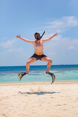 Funny man jumping in flippers and mask.