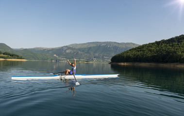 The young sportsman is rowing on the racing kayak
