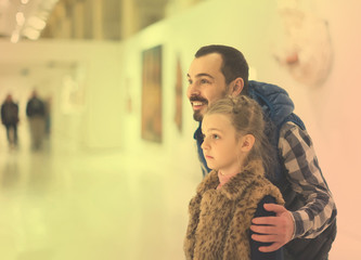 Obraz premium Father and daughter looking at ancient bas-reliefs in museum