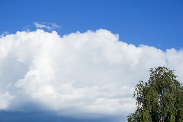 Blue sky, big cloud approaching abrupt change in the weather