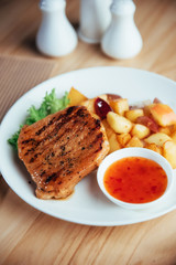 Steak with crispy golden fries and tomato spicy sauce