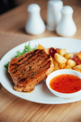 Steak with crispy golden fries and tomato spicy sauce