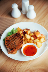Steak with crispy golden fries and tomato spicy sauce