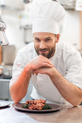 Portrait of chef cook in uniform with prepaired delicious dish at the restaurant kitchen