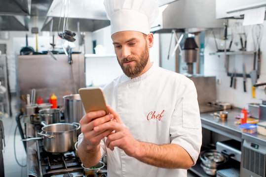 Chef cook using smart phone at the restaurant kitchen