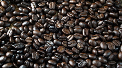 Dark roasting coffee beans put on a wood table