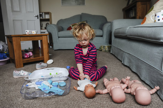 Girl playing with dolls at home