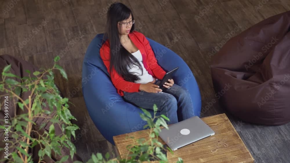 Poster Vietnamese girl using app for calling. Female enjoy conversation use application and internet on touch screen tablet.