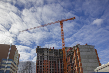 Fototapeta na wymiar Crane and building construction site against blue sky.