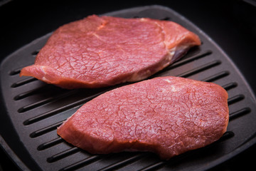 Raw steak frying on a pan-grill. Grill beef steak. Portions thick beef juicy sirloin steaks on grill teflon pan 