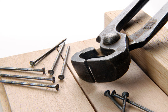 black pincers and nails on a white background