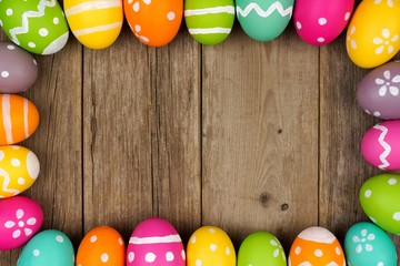 Colorful Easter egg frame against a rustic wood background