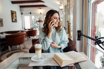 Woman in cafe talking on cell phone