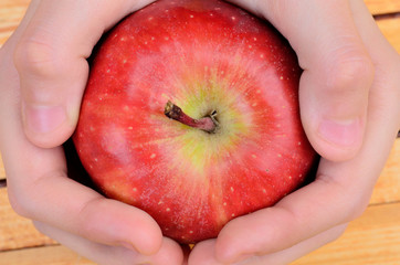 hand hold apple on table