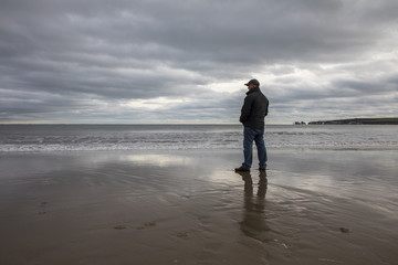 man in colder weather looking out to sea