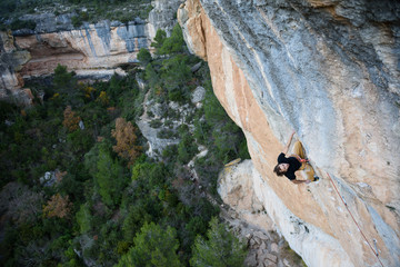 Outdoor sport. Rock climber ascending a challenging cliff. Extreme sport climbing. 