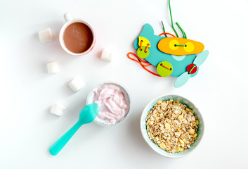 concept kid breakfast with yogurt top view white background