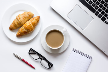 Coffee break in office on desk with laptop top view