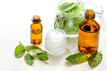 organic cosmetics with herbal extracts of mint on wooden background