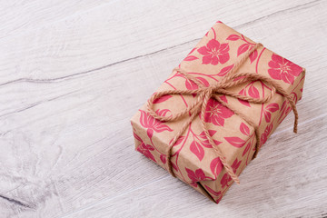 Gift wrapped with rope. Present box on wooden backdrop. Holiday is time of joy. Happiness from receiving a gift.
