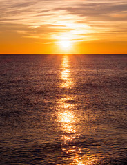 sunset casting long highlight over sea