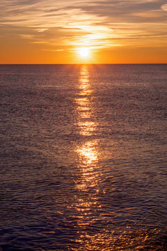 sunset casting long highlight over sea