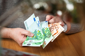 male hands think Euro banknotes. Euro banknotes in denomination of 100 and 50 Euro. Wealthy...