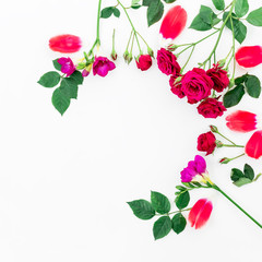 Frame with red roses, leaves, freesia and tulip petals isolated on white background. Flat lay, top view