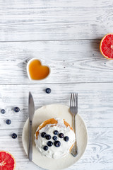 Breakfast concept with flowers on wooden background top view