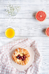 Breakfast concept with flowers on wooden background top view