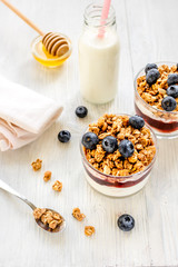 Fitness breakfast with granola, milk and honey on white background