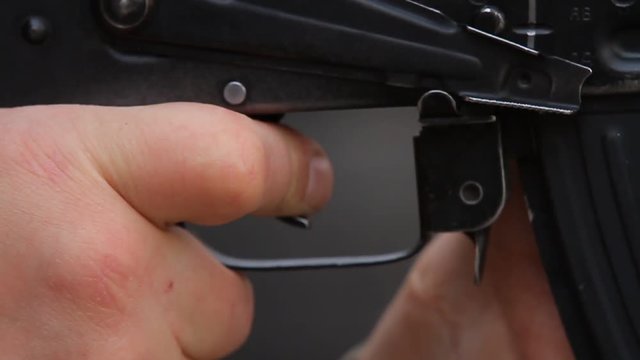 Closeup of a finger on the trigger Kalashnikov assault rifle, single shot.