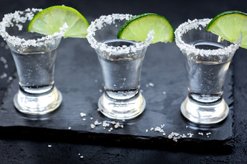 Set for tequila party with lime and salt on black background